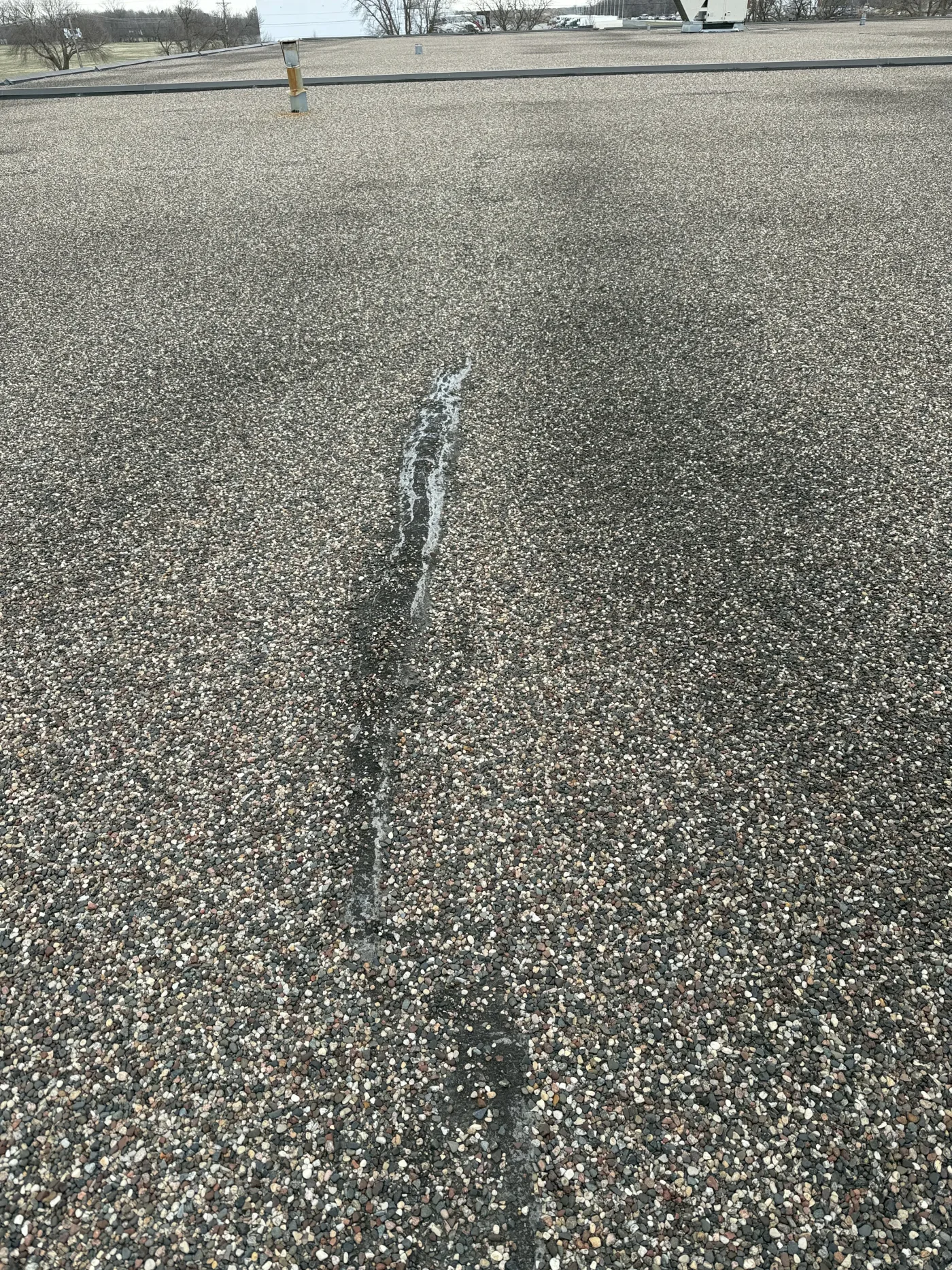 Aging seam on tar and gravel roof needing repair
